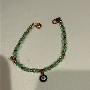 Green Beaded Bracelet with Gold Accents and Blue Eye Charm